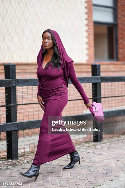 Coco Bassey wears a purple long scarf over the head, a low-neck long maxi flowing dress, outside Alberta Ferretti, during the Milan Fashion Week -...