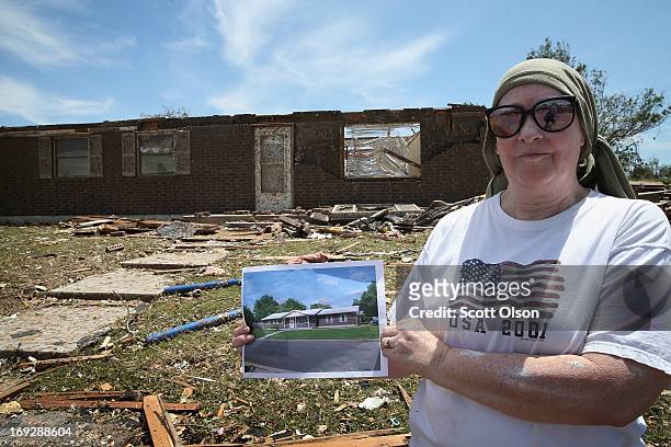 Lean Newbury holds up a picture of her father's home before it was destroyed by a tornado that ripped through the area on May 22, 2013 in Moore,...