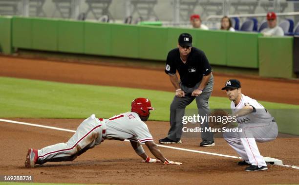 Jimmy Rollins of the Philadelphia Phillies dives into first base during a pick off attempt in the first inning by First baseman Nick Green of the...