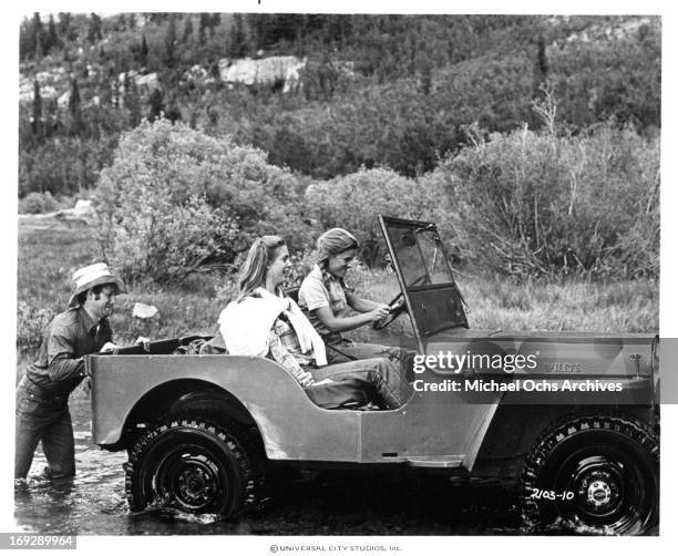 Timothy Bottoms pushes a jeep with Marilyn Hassett and Gretchen Corbett in a scene from the film 'The Other Side Of The Mountain: Part II', 1978.