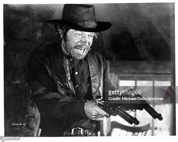 Stephen Boyd pointing pistols in a scene from the film 'The Man Called Noon', 1973.