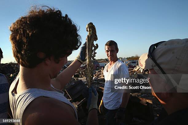 Michael Phillips and Bryan Green look over a war trophy which they helped the homeowner find buried in the rubble of his home after it was destroyed...