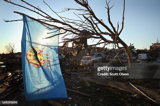 An Oklahoma state flag hangs in a tree next to a destroyed home across the street from the Plaza Towers Elementary School where several children died...
