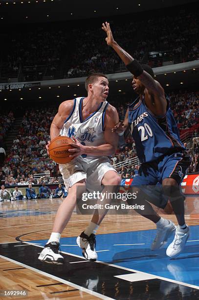 Mike Miller of the Orlando Magic looks to pass while defended by Larry Hughes of the Washington Wizards during the NBA game at TD Waterhouse Centre...