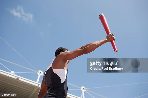 runner running with torch on track - the olympic games stock pictures, royalty-free photos & images