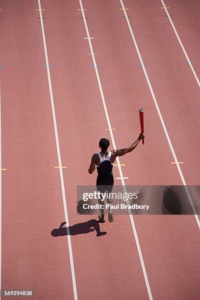 läufer laufen mit fackel am track - internationales sportereignis stock-fotos und bilder