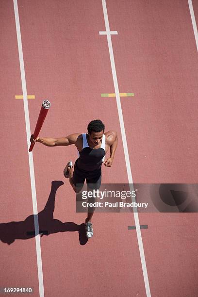 läufer laufen mit fackel am track - olympische spiele stock-fotos und bilder