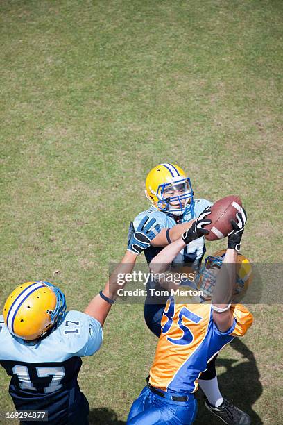 football player catching football - tackle american football positie stockfoto's en -beelden
