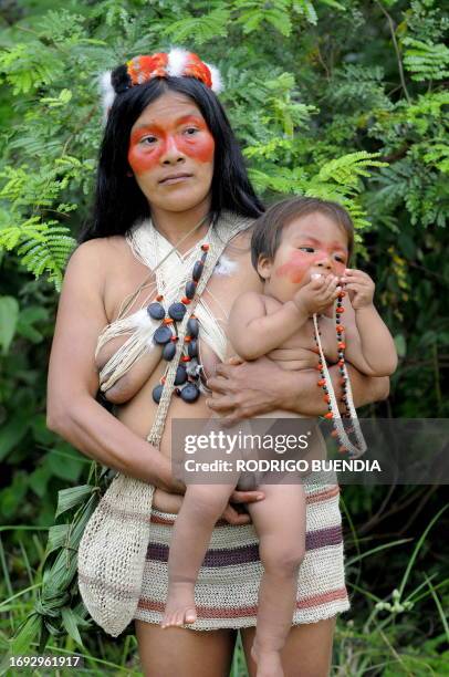An Ecuadorean Waorani native holds her boy at the Yasuni National Park, at the Ecuadorean Amazon forest, on August 21, 2010. AFP PHOTO / RODRIGO...