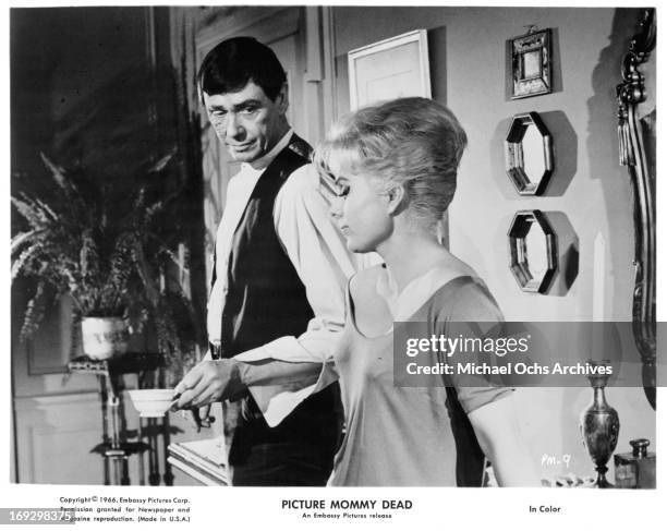 Maxwell Reed has tea with Martha Hyer in a scene from the film 'Picture Mommy Dead', 1966.