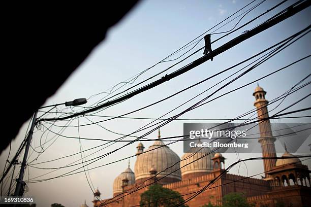 Electricity and telephone wires run above a street near the Jama Masjid mosque in the Old Delhi area of New Delhi, India, on Friday, May 3, 2013....