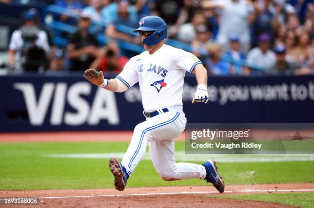 Davis Schneider of the Toronto Blue Jays scores a run on a wild pitch by Cole Ragans of the Kansas City Royals in the sixth inning at Rogers Centre...