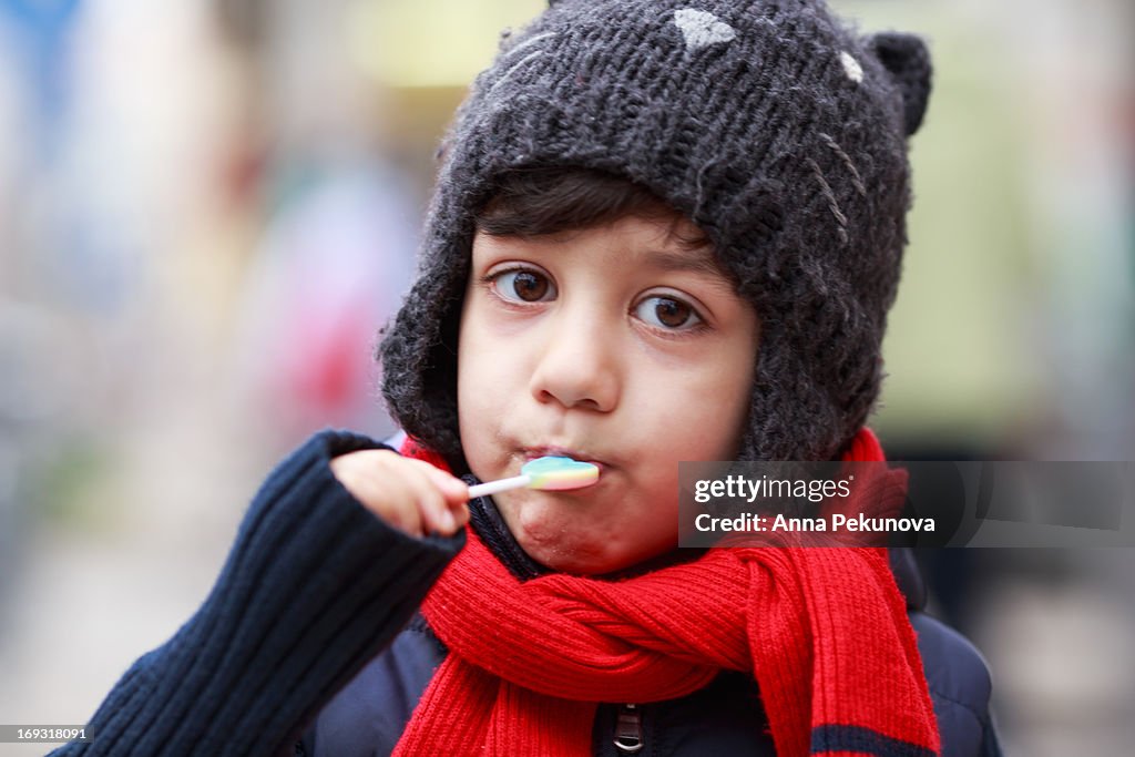Boy eating heart-shaped lollipop