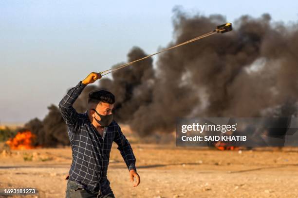 Palestinian uses a slingshot amid clashes with Israeli security forces in Khan Yunis in the southern Gaza Strip on September 27 following a protest...