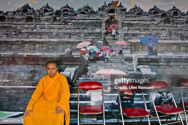 Buddhist monk sits in front of borobudur wallpaper at the temple during Pindapata procession on May 23, 2013 in Magelang, Central Java, Indonesia. As...