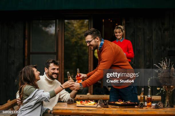 the joyous ambiance of a garden party, with a diverse group of people relishing a shared meal amidst nature's beauty - the party arrivals stock pictures, royalty-free photos & images