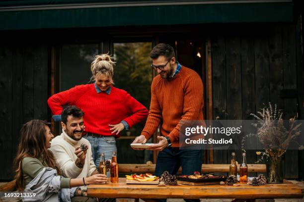 the joyous ambiance of a garden party, with a diverse group of people relishing a shared meal amidst nature's beauty - the party arrivals stock pictures, royalty-free photos & images