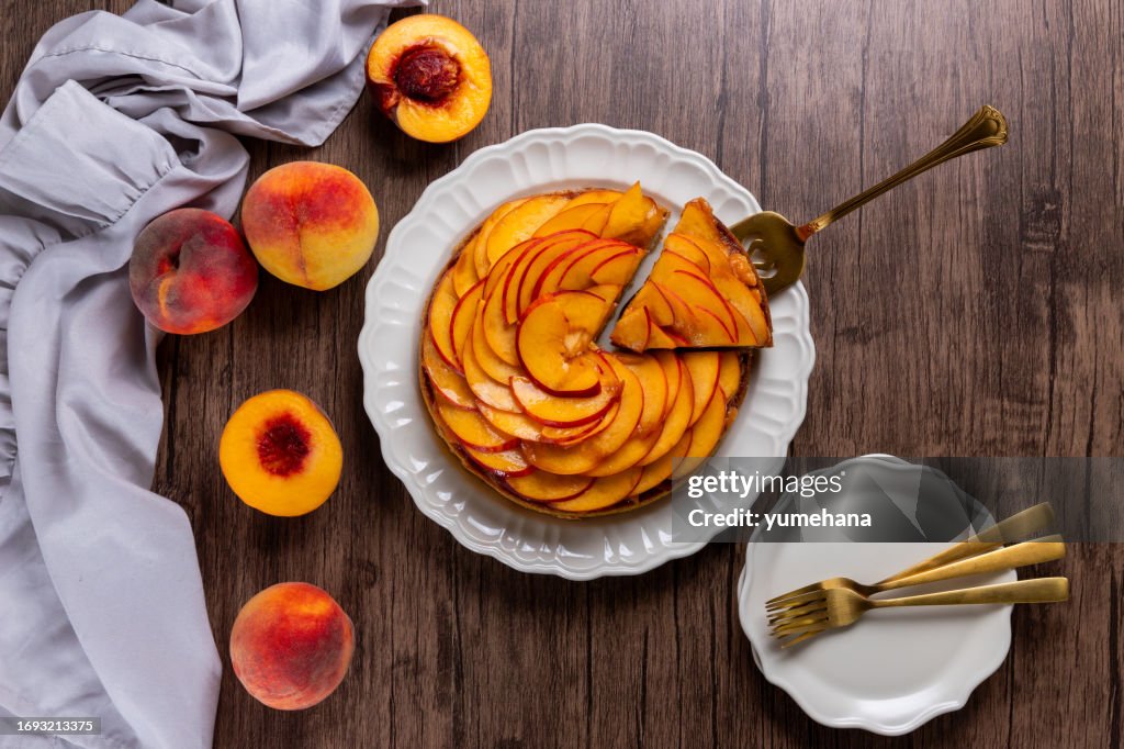 Fresh peach tart with almond cream close-up on a wooden table
