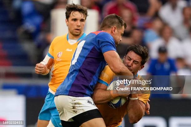 Uruguay's outside centre Felipe Arcos Perez is tackled by Namibia's left wing JC Greyling during the France 2023 Rugby World Cup Pool A match between...