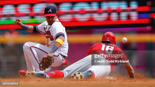 Nicky Lopez of the Atlanta Braves cant come up with the ball as Brandon Marsh of the Philadelphia Phillies steals second and then steals third during...