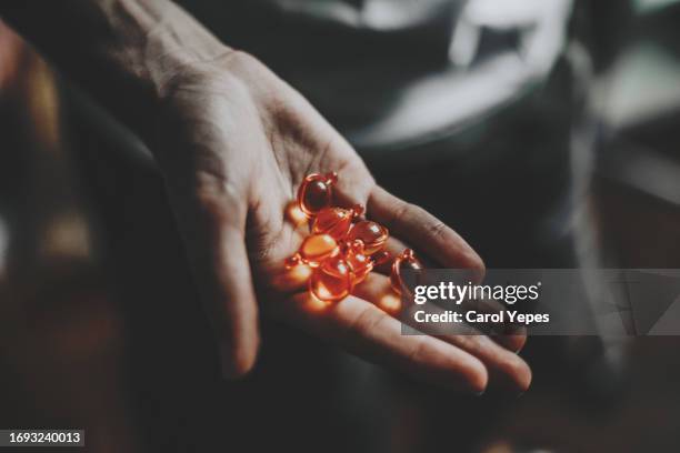 hand holding some supplements pills - antioxidant support stock pictures, royalty-free photos & images