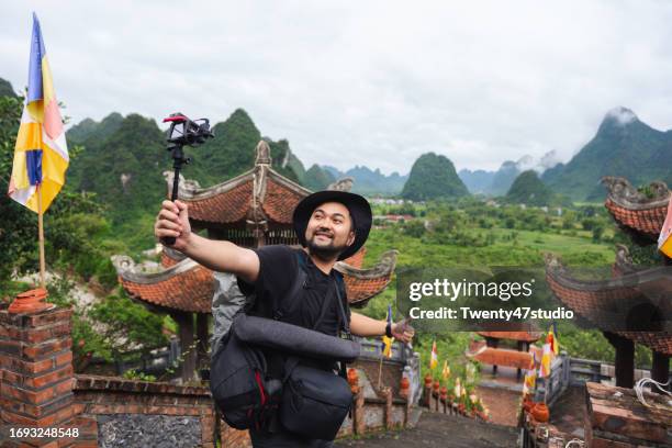 travel blogger filming video while traveling in vietnam - content japanese ethnicity stock pictures, royalty-free photos & images