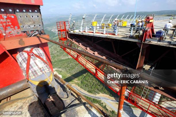Workers operate on the separate parts of the Millau bridge before they were joined 28 May 2004. Engineers brought the two central ends of the Millau...