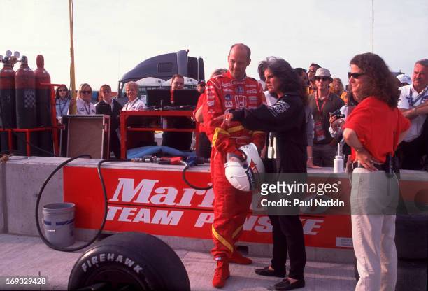 American actor Anthony Edwards listen to an unidentified woman on an unspecified race track, Chicago, Illinois, September 12, 1999.
