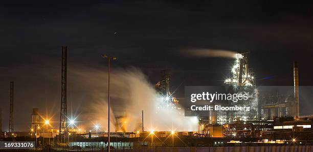 Buildings are seen illuminated as vapor rises from cooling towers at the steel works operated by Tata Steel Ltd. In Port Talbot, U.K. On Wednesday,...