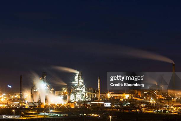 Buildings are seen illuminated as vapor rises from cooling towers at the steel works operated by Tata Steel Ltd. In Port Talbot, U.K. On Wednesday,...