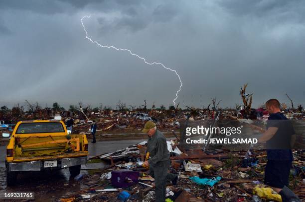 Lightning strikes during a thunder storm as tornado survivors search for salvagable stuffs at their devastated home on May 23 in Moore, Oklahoma....