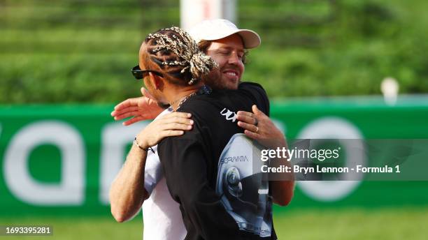 Lewis Hamilton of Great Britain and Mercedes and Sebastian Vettel embrace at the launch of the Buzzin' Corner biodiversity project during previews...