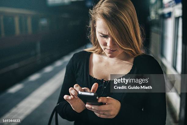 Woman using smart phone on railway station.