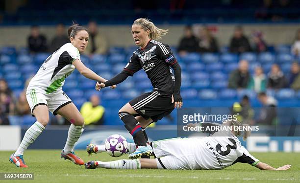 Lyon's French midfielder Camille Abily jumps over a tackle from Wolfsburg's Hungarian midfielder Zsanett Jakabfi during the UEFA Women's Champions...