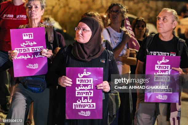 Arab and Jewish Israelis gather with placards before candles during a vigil against violence in the Arab community in the town of Basmat Tabun in...