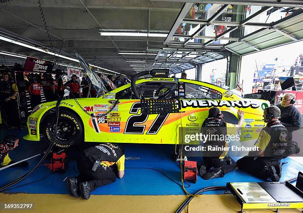 Paul Menard, driver of the Menards/Serta Chevrolet, sits in his car as crew members work during practice for the NASCAR Sprint Cup Series Coca-Cola...