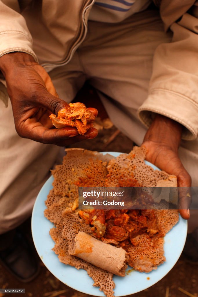 Man eating injera at a wedding party in Lalibela