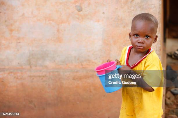 Young african boy drinking water, Togo.