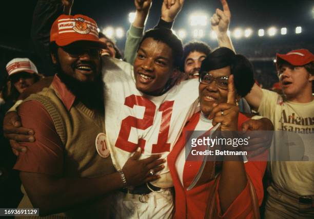 American football player Roland Sales, of Arkansas University, is hugged by his dad Fred and mum Mattie after leading his team to victory in the...
