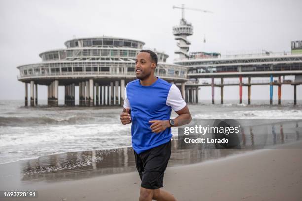 a black male working out on the beach - scheveningen stock pictures, royalty-free photos & images