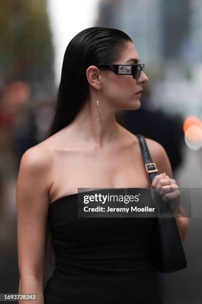 Guest is seen outside Altuzarra show wearing black sunnies, black shoulder free top and a black leather Gucci Jackie handbag on September 11, 2023 in...