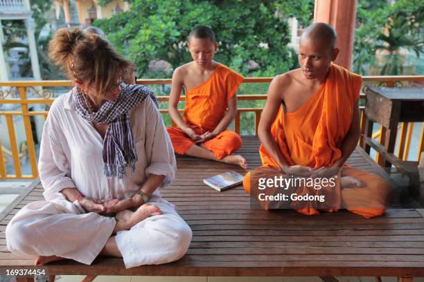 Wat Ounalom, Phnom Penh. European woman visiting a cambodian pagoda. Learning the basics of buddhist meditation.