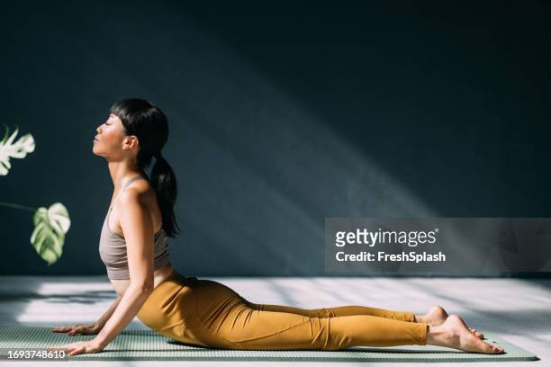cultivating vitality: japanese woman's journey to wellbeing through yoga - cobra stretch stock pictures, royalty-free photos & images