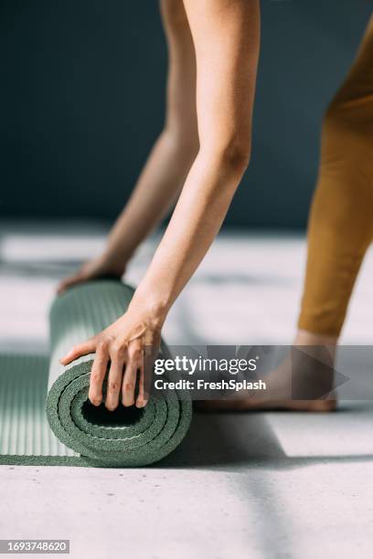 préparation à l’exercice: dérouler le tapis de yoga - tapis de sol photos et images de collection