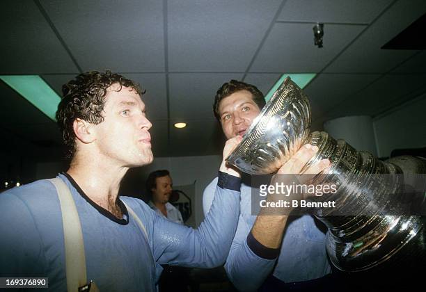 Dave Hunter and Dave Semenko of the Edmonton Oilers celebrate in the locker room with the Stanley Cup Trophy after the Oilers defeated the New York...