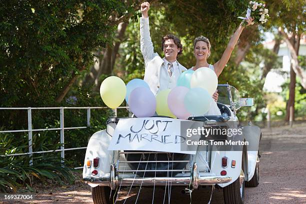 bride and groom riding in convertible - bride and groom wedding car stock pictures, royalty-free photos & images