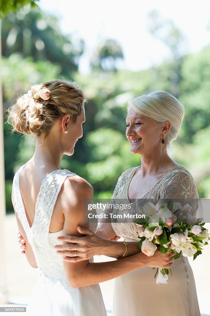 Mother hugging bride on wedding day