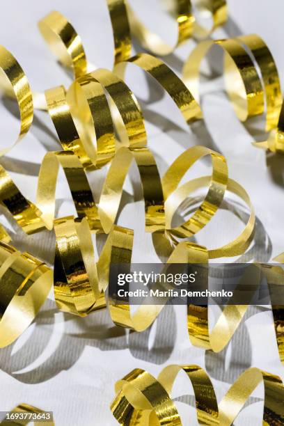 festive background with golden serpentine, streamers, ribbons - birthday streamers stockfoto's en -beelden