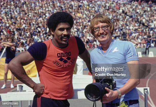 Olympic decathlete Daley Thompson from Great Britain and Allsport photographer Tony Duffy holding a 35mm SLR Nikon F2 camera with a Nikkor ED 300mm...