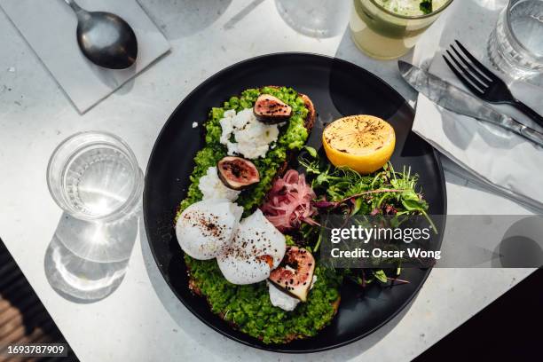 flat lay of a plate of vegetarian brunch with green smoothie served on table at cafe - english breakfast stock-fotos und bilder